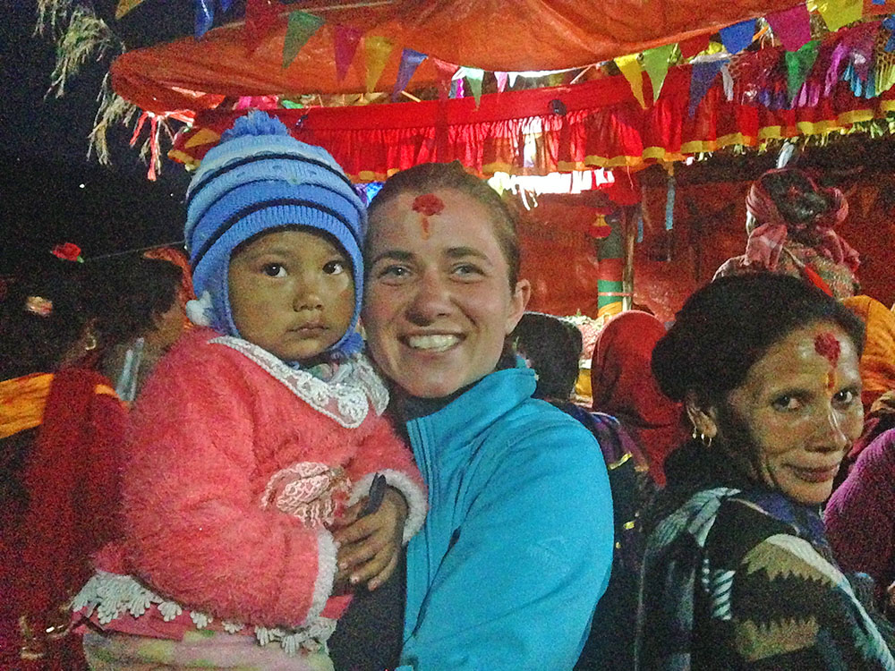 Europejka w świątyni trzyma nepalskie dziecko