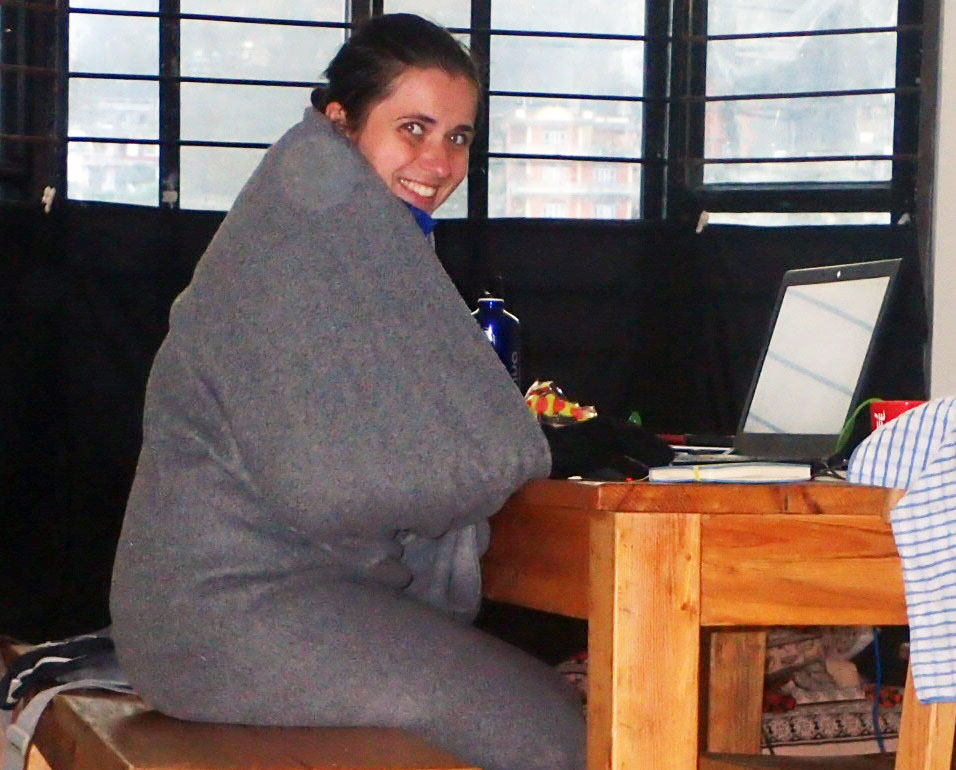 Dziewczyna przy biurku zawinięta w gruby koc